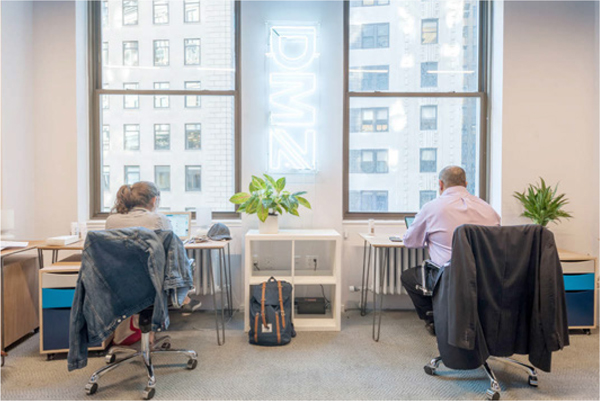 Image of two people working in the NYC office of DMZ