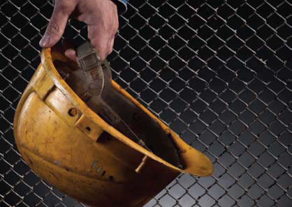 image shows a man holding a yellow hard hat