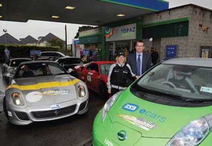 Image shows a lady and a man standing beside an ecar with a Topaz in the background.