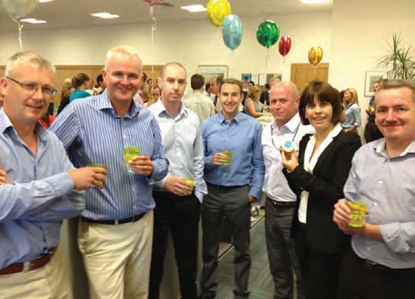 Six men and one woman pose for a pic at a conference.